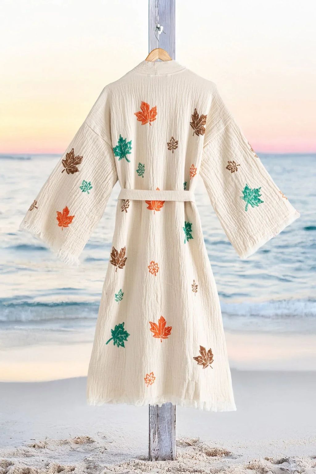 Beige Kimono mit bunten Herbstlaub-Print, Strandhintergrund