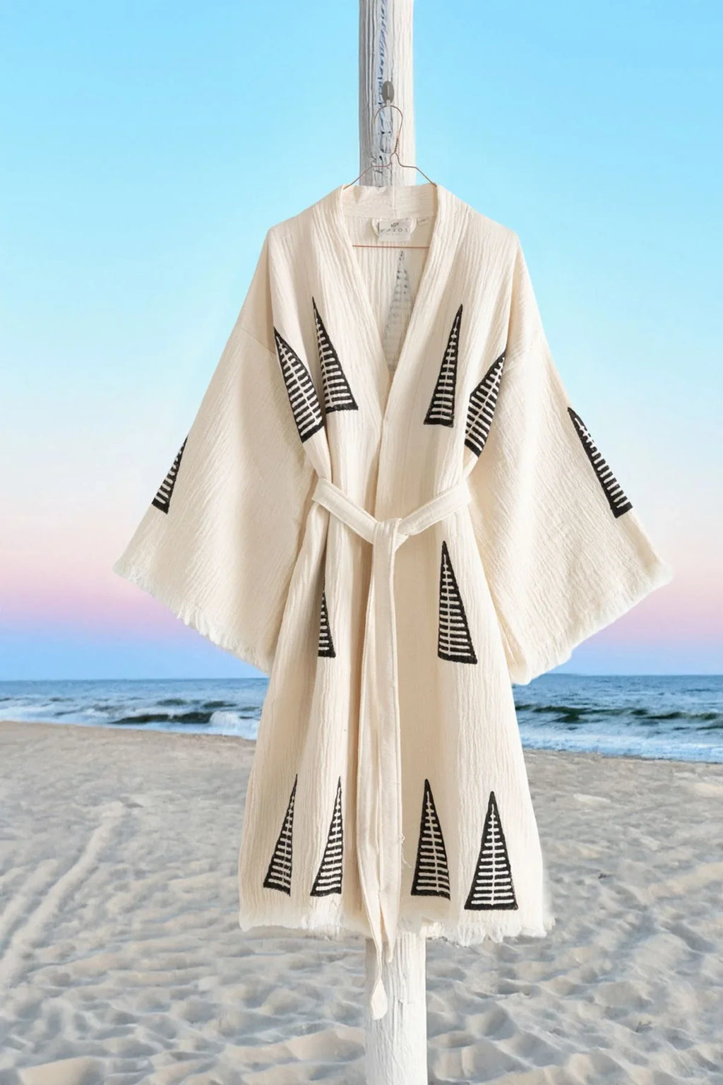 Beige Kimono mit geometrischen Mustern am Strand, ideal für entspannte Momente