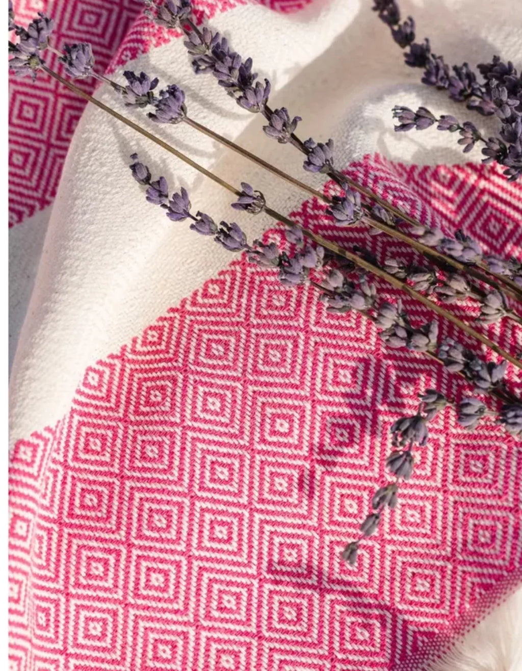 Waschbarer Teppich mit geometrischem Muster in Rosa und Weiß, dekoriert mit Lavendelzweigen