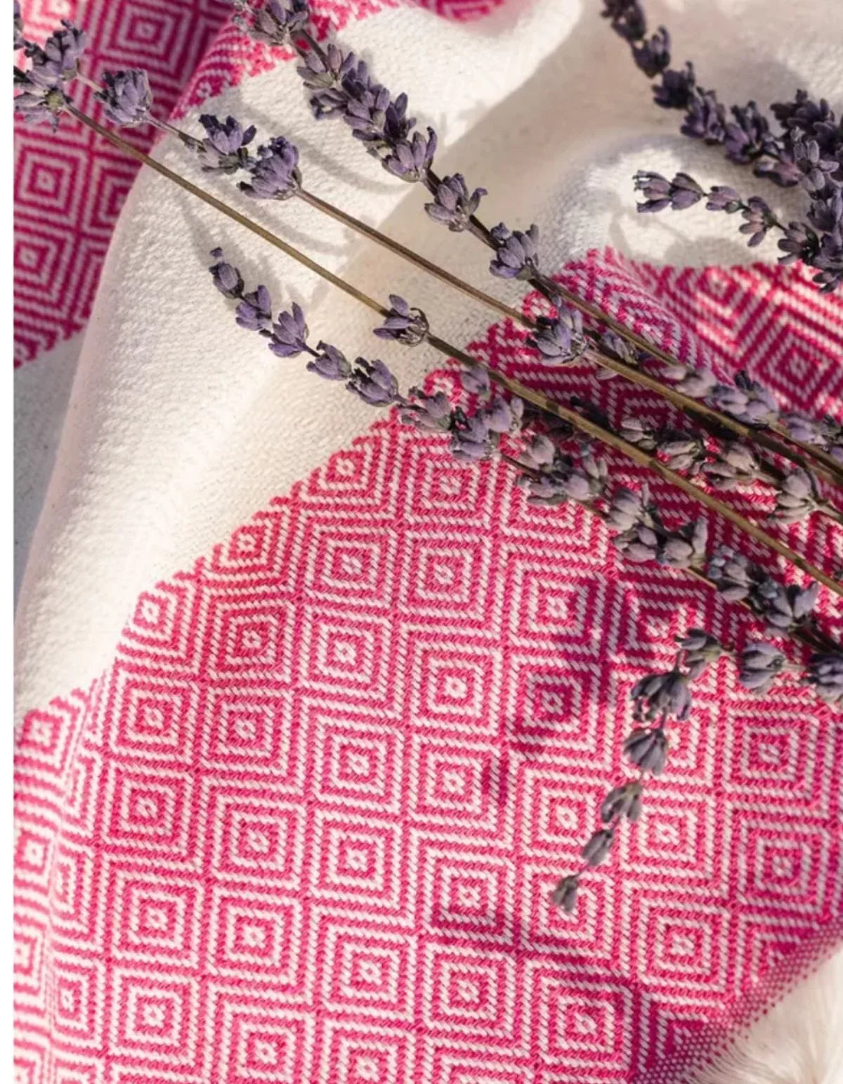 Waschbarer Teppich mit geometrischem Muster in Rosa und Weiß, dekoriert mit Lavendelzweigen