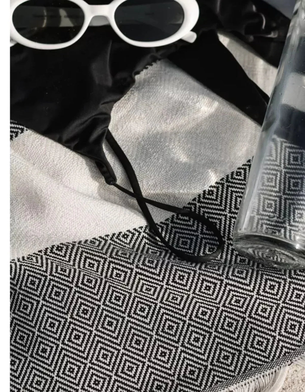 Waschbarer Bambusteppich mit geometrischem Muster, Sonnenbrille und Glas darauf