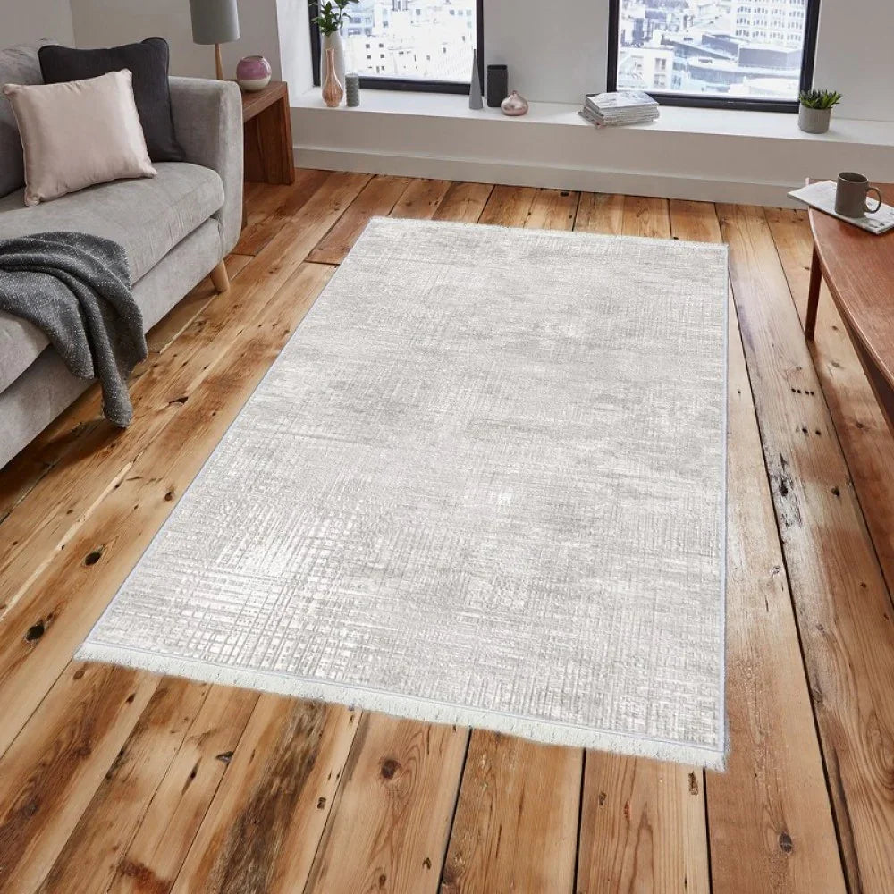 Waschbarer Teppich in Grau mit Fransen auf Holzboden im Wohnzimmer