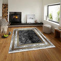 Modern living room with a black and gold patterned washable area rug on wooden floor.