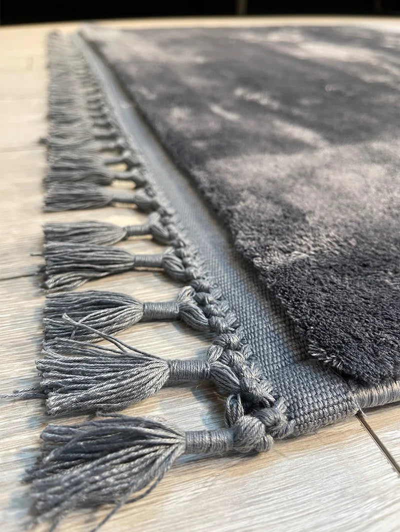 Grauer waschbarer Teppich mit Fransen und abstraktem Muster, ideal für moderne Wohnräume